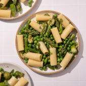white plates with pasta, peas and asparagus