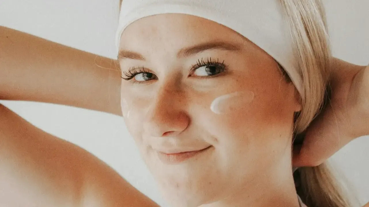 Woman_with_white_headband_on_and_a_swatch_of_face_moisturizer_on_her_face